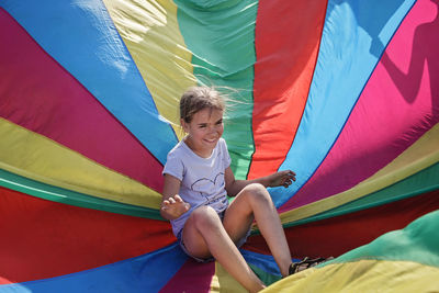 Full length of a boy with multi colored umbrella