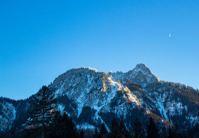 Scenic view of snowcapped mountains against clear blue sky