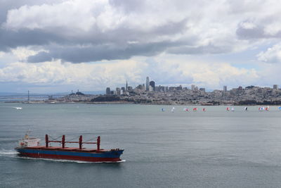 Boat in sea against sky in city