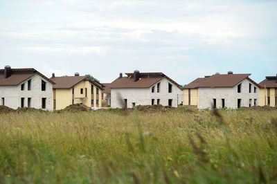 Houses on field against sky
