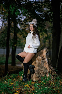 Portrait of woman standing on field in forest