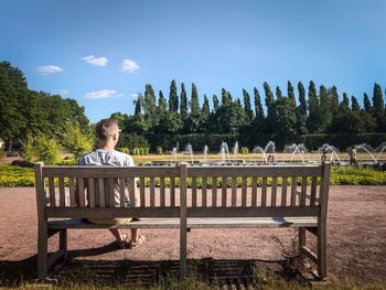 Man sitting on bench against trees