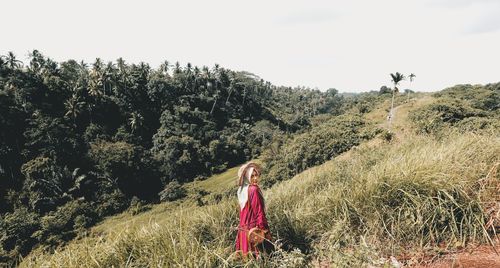 Woman standing on field against sky