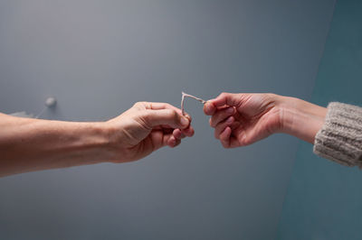 Midsection of people holding hands against white background