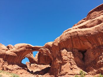 Low angle view of rock formations against blue sky