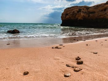 Scenic view of rocks on beach against sky