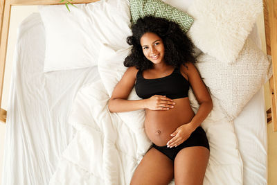 Directly above shot of pregnant woman lying on bed