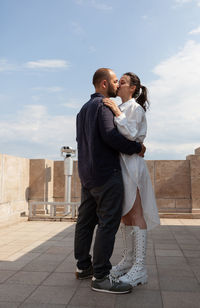 Rear view of couple standing against the sky