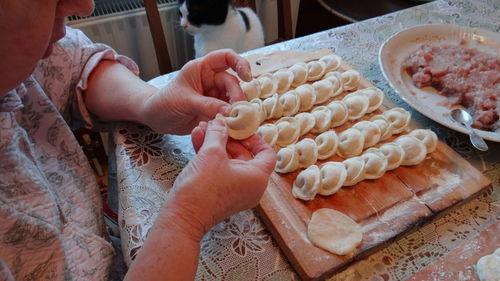 Midsection of woman making dumplings in kitchen at home