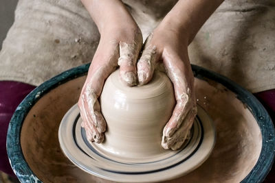 Creating a jar or vase of white clay close-up. master crock. man hands making clay jug macro. 