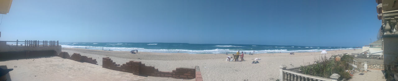 Panoramic view of beach against clear blue sky