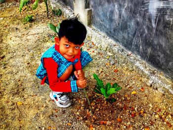 An early childhood education child is caring for flowers using a small wood