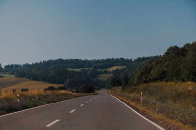 Road passing through landscape against clear sky