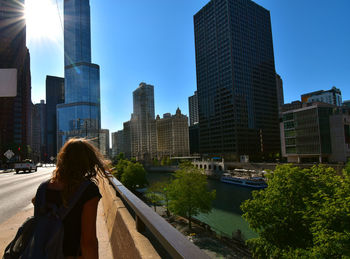 Rear view of woman against buildings in city