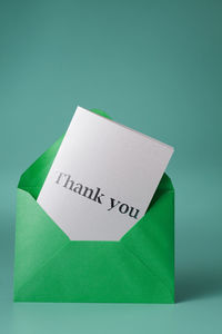 Close-up of blank paper in envelope against green background