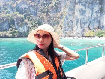 Portrait of woman in hat against sea