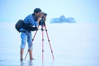 Man photographing with camera at beach