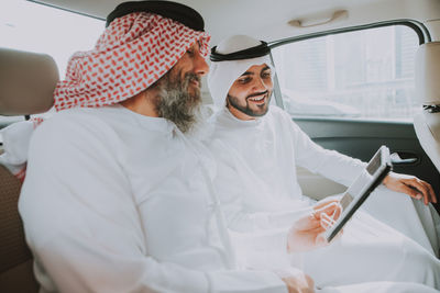 Men wearing dish dash traveling in car