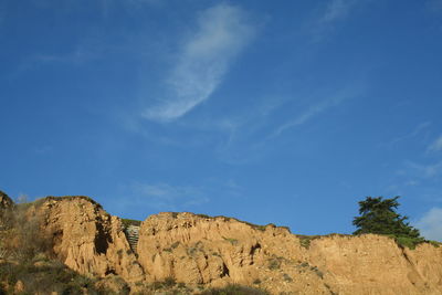 Low angle view of rock formations against blue sky