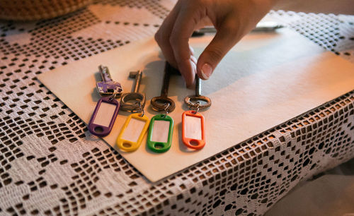 Cropped image of hand picking key on table