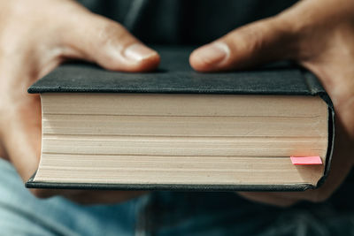 Close-up of man holding book on table