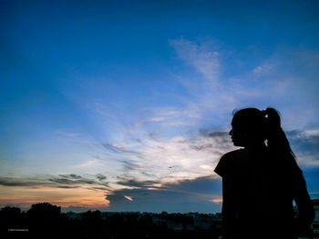 Silhouette woman standing against sky