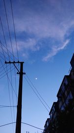 Low angle view of silhouette electricity pylon against sky