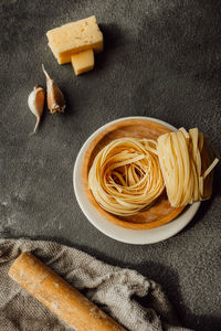 Making homemade noodle on dark kitchen with cheeses and garlic