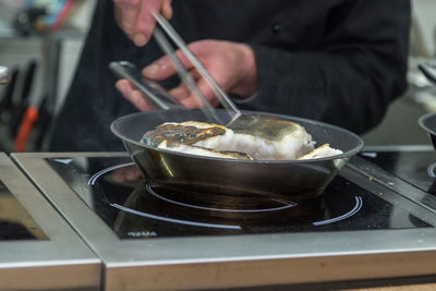 Midsection of man preparing food in kitchen