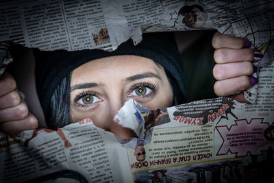 Portrait of young woman tearing paper