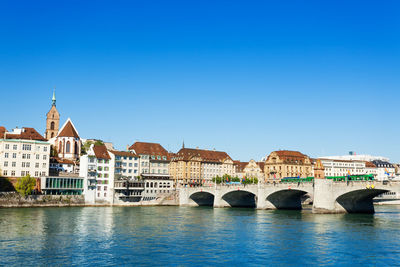 Arch bridge over river against buildings in city