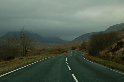 Empty road along countryside landscape