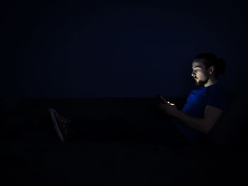 Young man using mobile phone at night