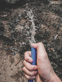 Close-up of hand holding ring over water