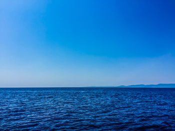 Scenic view of sea against clear blue sky