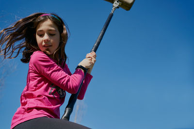 Girl on a children's zip line with a blue sky background