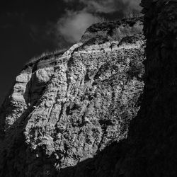 Low angle view of rock formation against sky