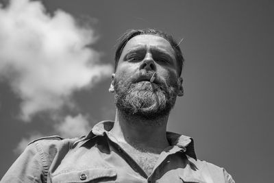 Low angle view of man looking away against sky