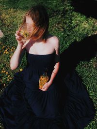 Midsection of woman sitting on field