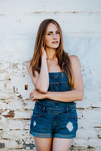 Portrait of beautiful woman standing against wall