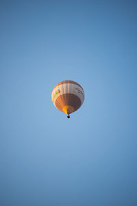 Low angle view of hot air balloon against clear blue sky