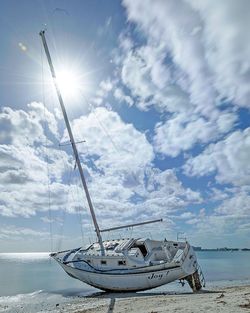 Sailboat moored on sea against sky