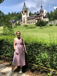 Portrait of woman standing against building