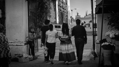 Rear view of people standing on street market