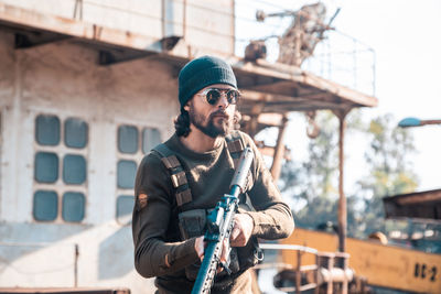 Young man wearing sunglasses standing against built structure