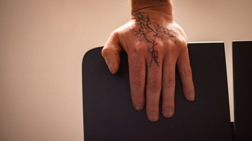 Close-up of human hand against wall