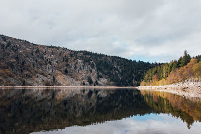 Scenic view of lake by mountain against sky