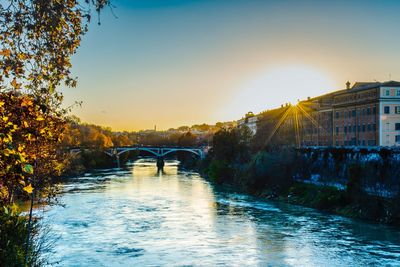 Bridge over river against sky during sunset
