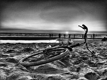 Bicycles on beach against sky