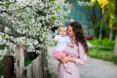 Mother with daughter by cherry tree